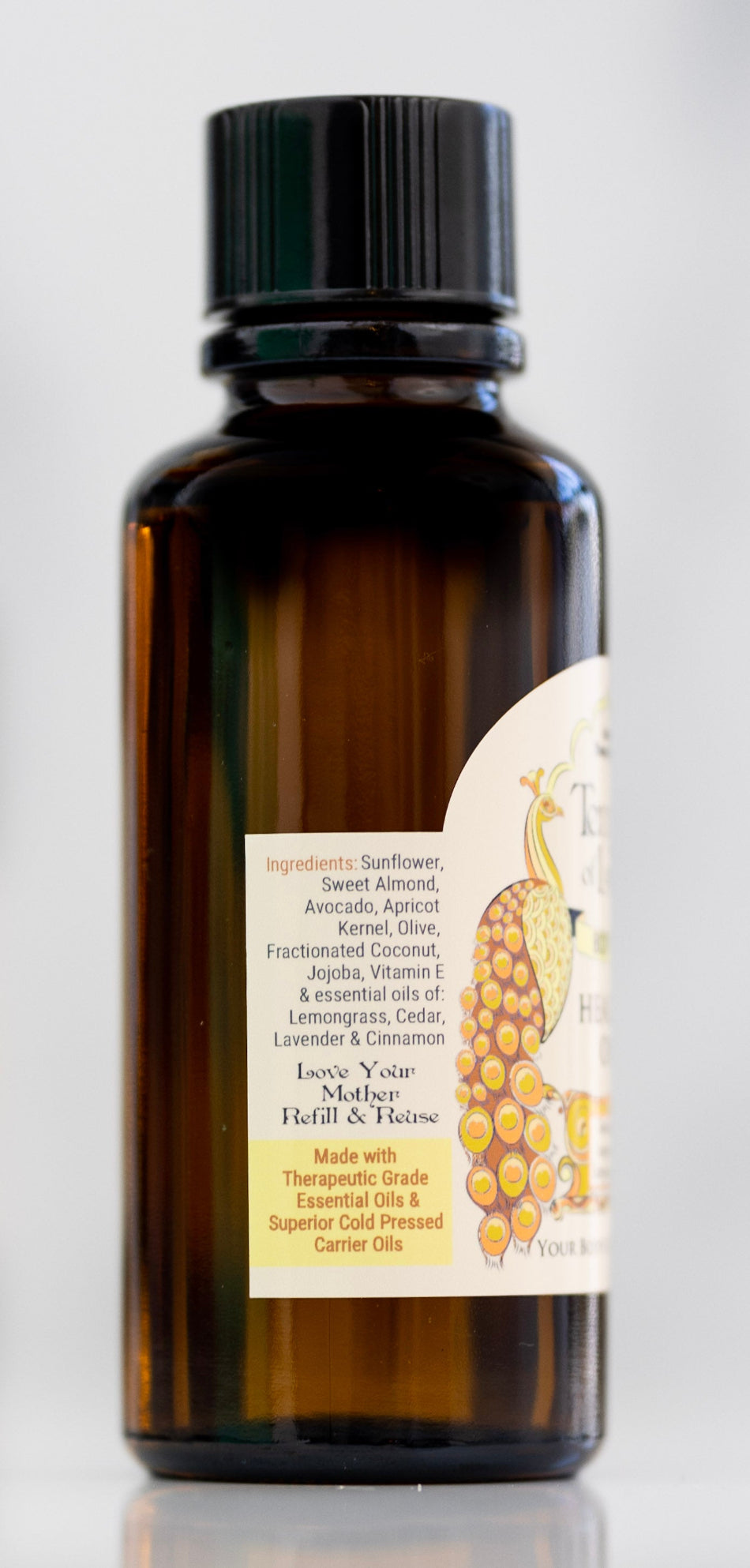 Bottle of Healers Oil warming massage oil with ingredient label on a white background