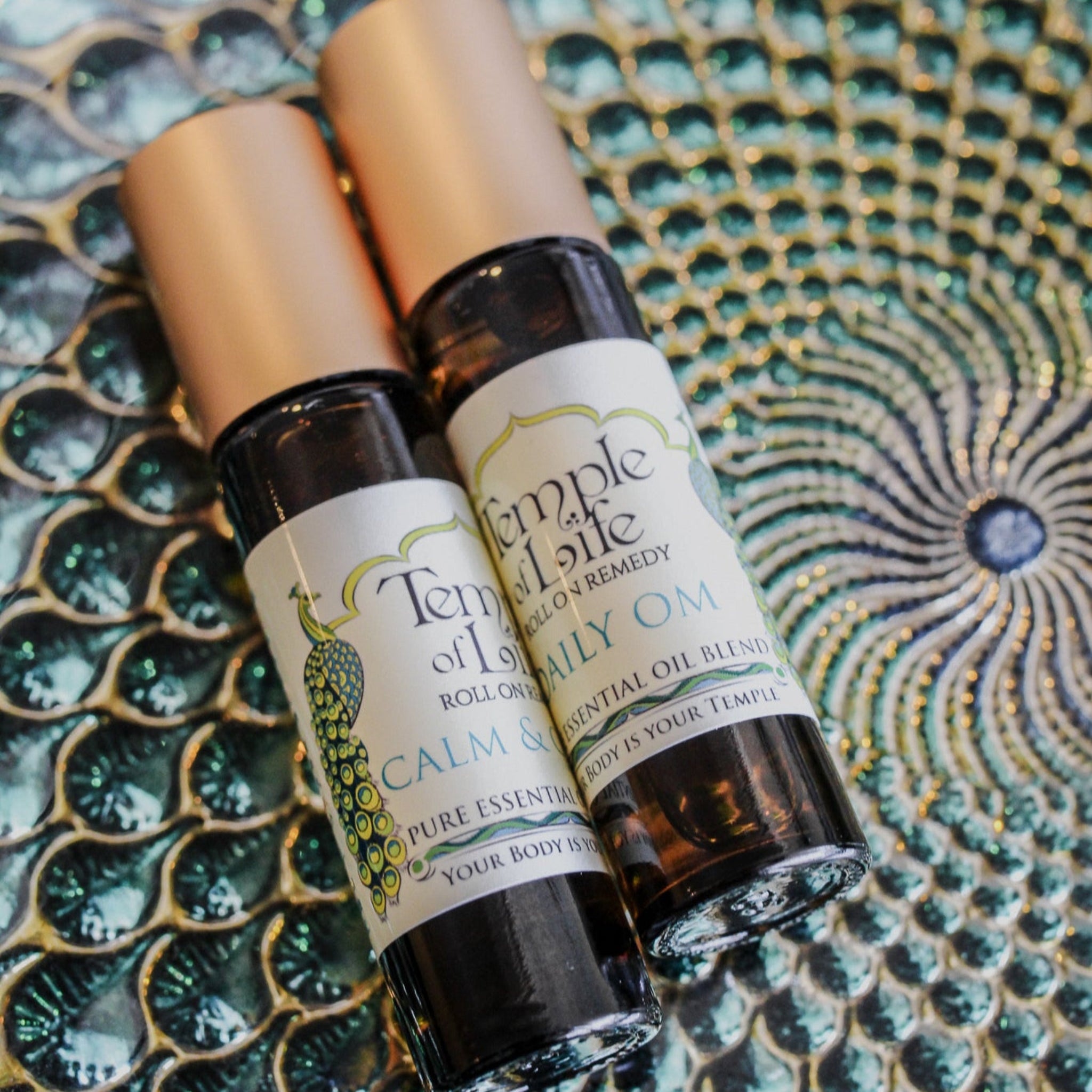 Two roll on bottles of 'Temple of Life' therapeutic essential oils labeled 'Calm & Clear' and 'Daily Om'.