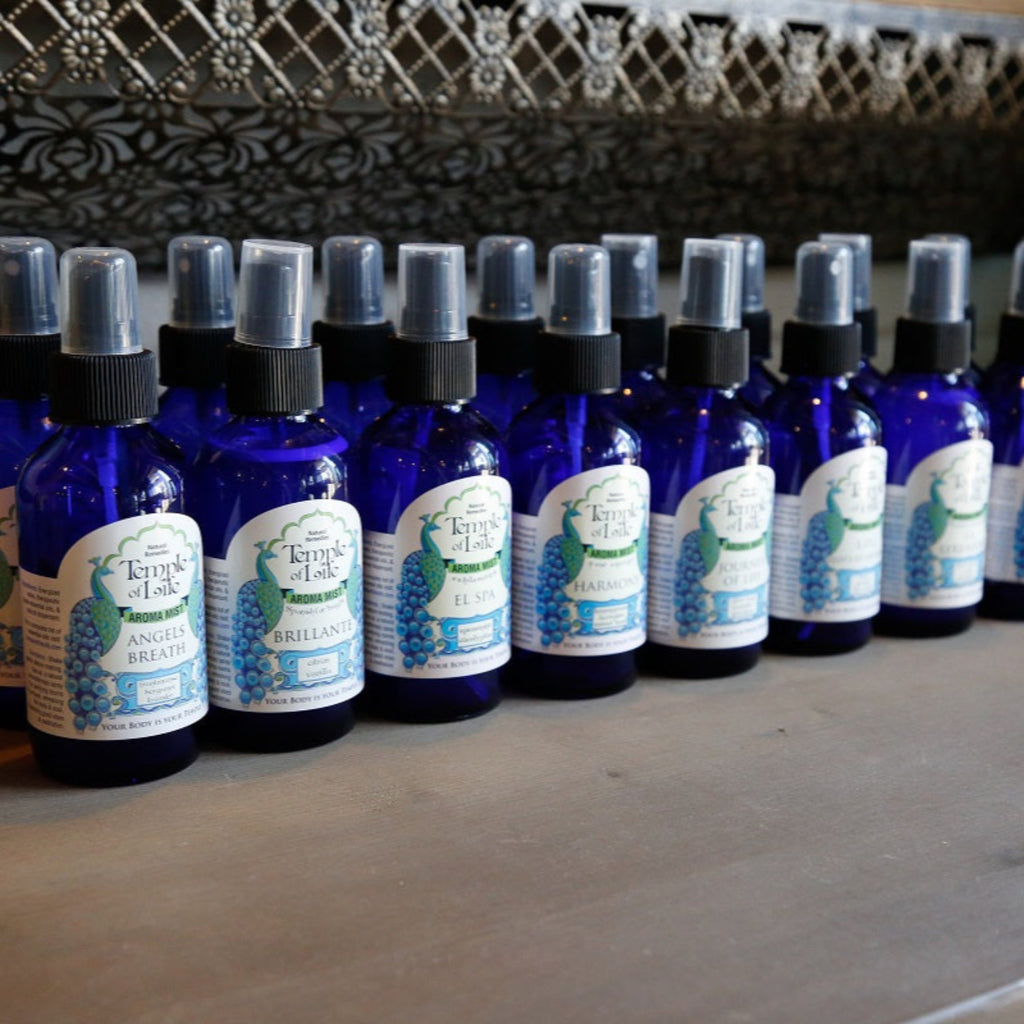 Row of blue bottles room sprays with labels on a wooden surface