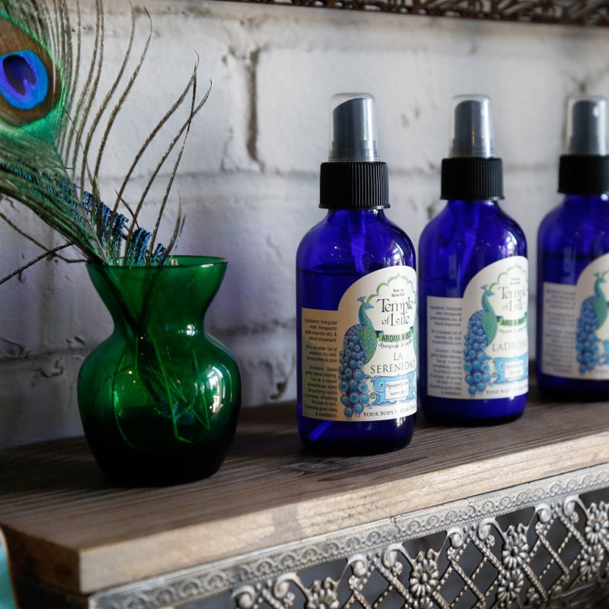 Row of blue bottle with aromatherapy room sprays on a decorative shelf.