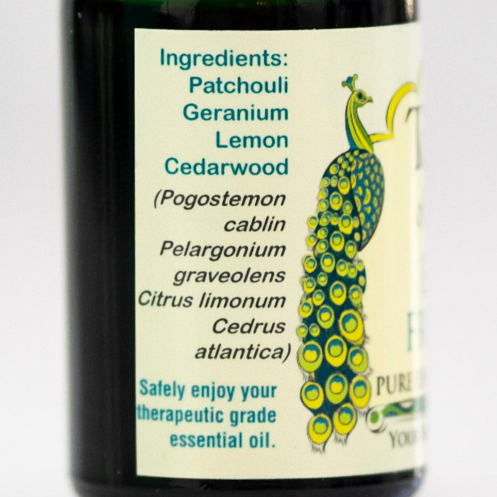 Bottle of patchouli essential oil blend with a peacock illustration and ingredient list on a white background